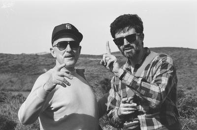 Half length portrait of Erik Bauersfeld (left) and Charles Amirkhanian pointing fingers at Point Reyes, CA (1980s)