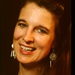 A head and shoulders portrait of Susan Stone, smiling, during Speaking of Music at the Exploratorium (1991)