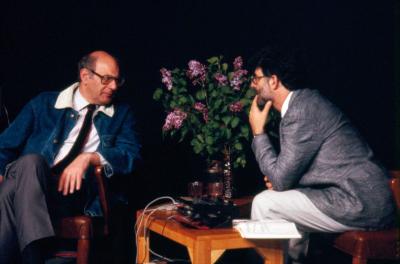 Three quarter length portrait of Mauricio Kagel and Charles Amirkhanian in discussion onstage during Speaking of Music at the Exploratorium, San Francisco (1988)