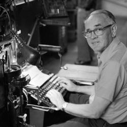 Walter Ellis, seated at keyboard, looking at the camera, 1973