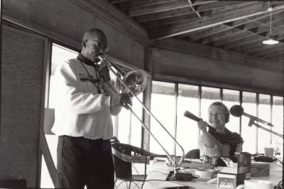 Julian Priester plays the trombone while Brunhild Meyer Ferrari holds a microphone, Woodside CA, (1999)