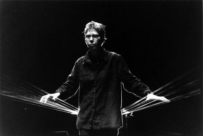 Ellen Fullman, half length portrait, standing in front of long string instrument, San Francisco, 2002 (cropped image)