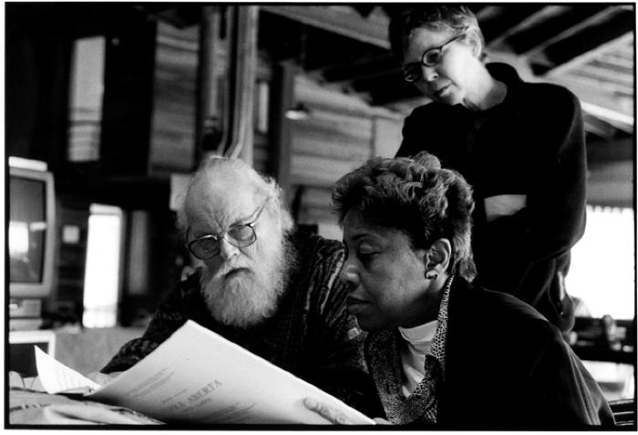 Lou Harrison, Tania León, and Ellen Fullman, head and shoulder portrait, looking at musical score, Woodside CA, (2002)