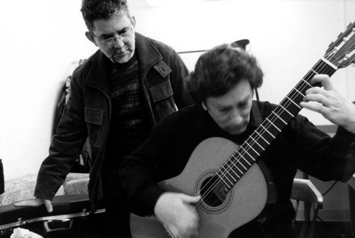 Ricardo Tacuchian looks over the shoulder of guitarist David Tanenbaum, 2002 (cropped image)