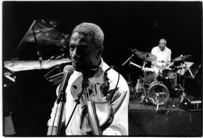 Head and shoulders portrait of Billy Bang with violin, in front of a microphone during a performance for the 11th Other Minds Festival, San Francisco (2005)