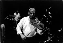 Half length portrait of Billy Bang playing the violin onstage with members of his quintet during the 11th Other Minds Festival, San Francisco (2005)