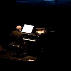 Michael Nyman, full length portrait, seated at piano, back to camera, facing slightly right, ver. 4, San Francisco, CA., (2005)