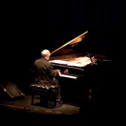 Michael Nyman, full length portrait, seated at piano, back to camera, facing slightly right, ver. 1, San Francisco, CA., (2005)