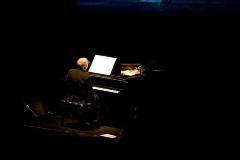 Michael Nyman, full length portrait, seated at piano, back to camera, facing slightly right, ver. 4, San Francisco, CA., (2005)