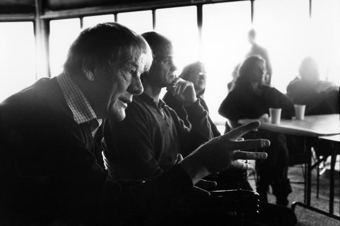 Per Nørgård, head and shoulders portrait, facing right, with Markus Stockhausen, Joëlle Leandre. Maja Ratkje, and others in background, Woodside CA, 2006