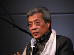 Chinary Ung, head and shoulders portrait, facing slightly left, holding microphone, San Francisco