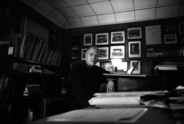 Arthur C. Berdahl, three-quarter length portrait, facing forward, arm resting on piano, 1976