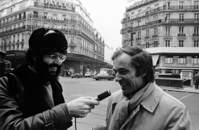 Charles Amirkhanian holds a microphone while interviewing Bernard Heidsieck on a street in Paris, 1973