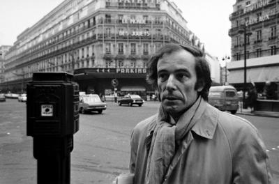 Bernard Heidsieck, head and shoulders portrait with "Les Monde des Jouets" in background, Paris, 1973