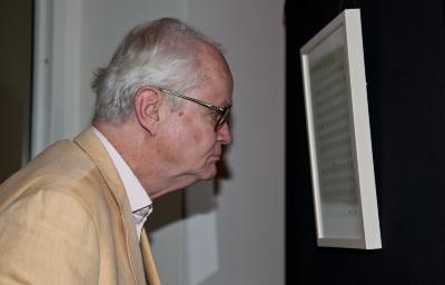 Tom Johnson, head and shoulder portrait, looking right, examining score