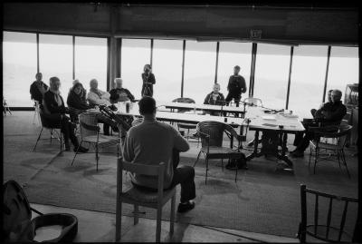 Gyan Riley (back to camera), sitting and playing guitar as OM 15 composers and organizers watch and listen, Woodside CA., (2010)