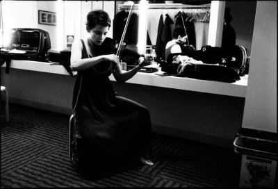 Carla Kihlstedt, full length portrait, seated, playing the violin in the green room, San Francisco CA., (2010)