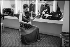 Carla Kihlstedt, full length portrait, seated, playing the violin in the green room, San Francisco CA., vs 2 (2010)
