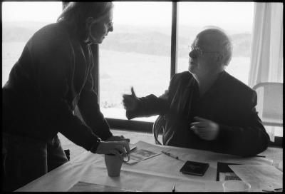Half length portrait of Janice Giteck and Louis Andriessen, seated, in discussion, Woodside CA (2011)