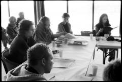 OM 18 artists seated around a table reviewing score pages during discussions at the Djerassi Resident Artists Program, Woodside CA (2013)