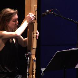 Anna Petrini seated onstage with her Paetzold contrabass recorder during the second concert of OM 18, vs. 9, San Francisco CA (2013)