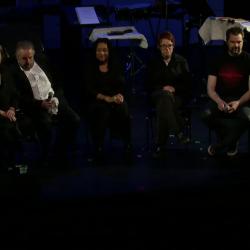 Panel discussion participants seated onstage prior to the third concert of OM 18, vs.2, San Francisco CA (2013)