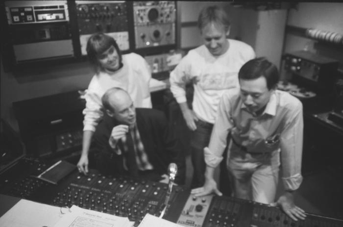 Brian Eno at the control board with KPFA staff during Brian Eno Day, 1988