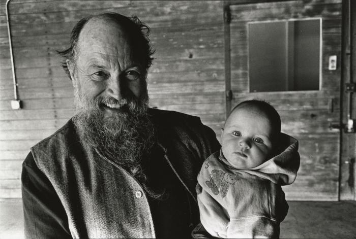 Terry Riley holding grandchild, head and shoulders portrait, facing forward, Woodside CA, (1995)