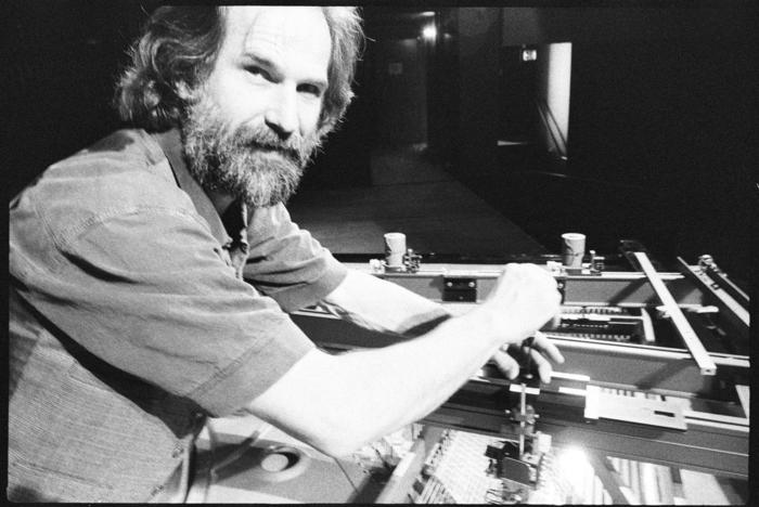 Trimpin, heads and shoulders portrait, adjusting interior of piano, San Francisco, 1993