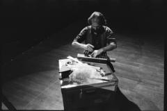 Trimpin, seated, working on a control device for a modified piano, 1993