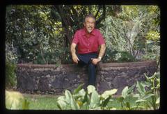 Conlon Nancarrow making a funny face while sitting in his garden, 1969