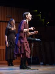 Meredith Monk singing while Katie Geissinger stands by during the third concert of OM 21, San Francisco CA (2016)