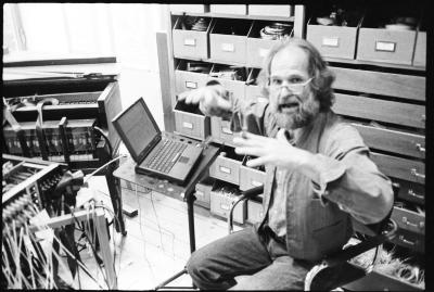 Trimpin, three quarter length portrait, seated in his studio, facing  forward, Seattle WA., (1998)
