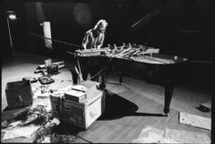 Trimpin, full length portrait, standing over and modifying piano, ver.2, 1993