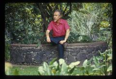 A portrait of Conlon Nancarrow seated in his garden on a stone bench, 1969