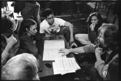 Philip Glass, Meredith Monk, Jon Jang, Julia Wolfe, and Trimpin, seated around a musical score, ver. 3, 1993