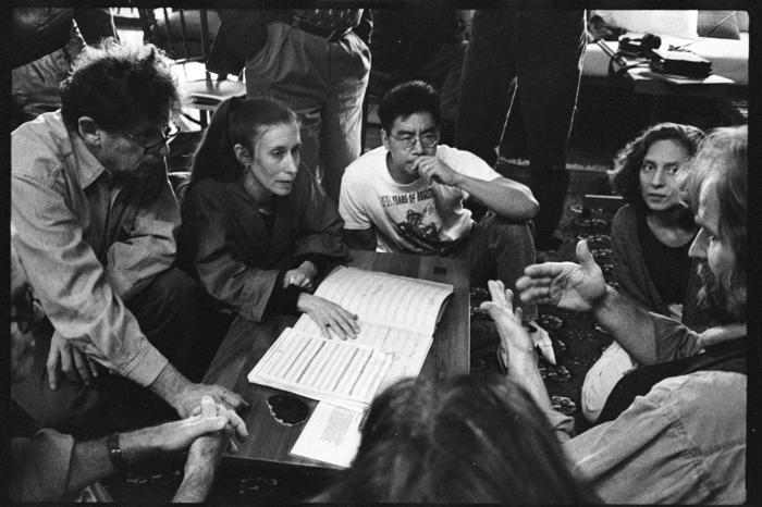 Philip Glass, Meredith Monk, Jon Jang, Julia Wolfe, and Trimpin, seated around a musical score, 1993