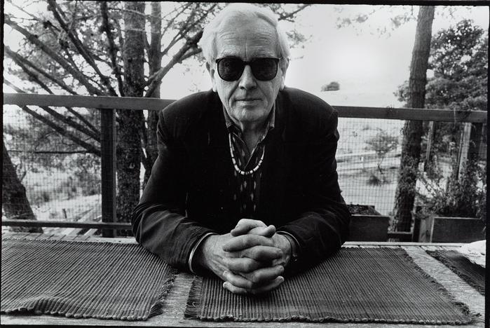 Portrait of Robert Ashley seated at an outside table during the Djerassi Resident Artists Program in Woodside, CA (1993)