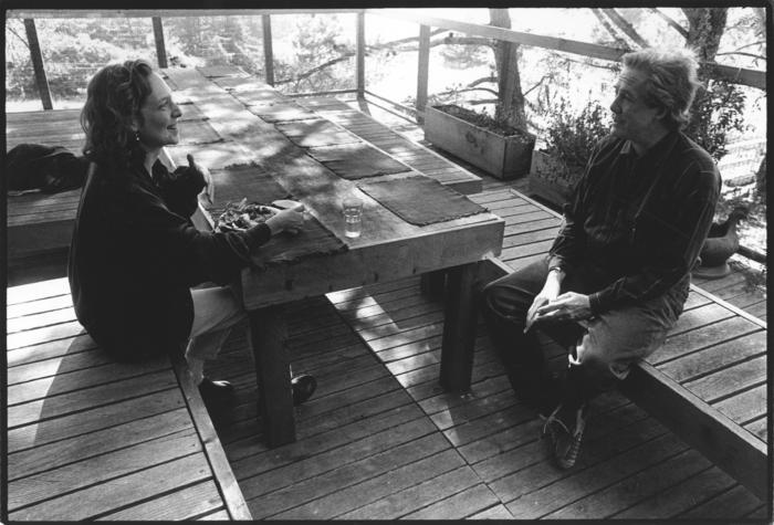 Julia Wolfe and Thomas Buckner seated across from each other at a table, outdoors in Woodside, CA (1993)