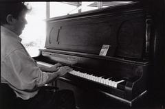 Philip Glass, playing the piano, seen from the side and slightly behind, Woodside CA, (1993)