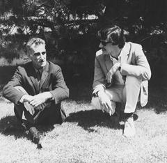 George Oppen and Charles Hanzlicek sitting on the grass outside the Arena Theater in Fresno, CA (1967)