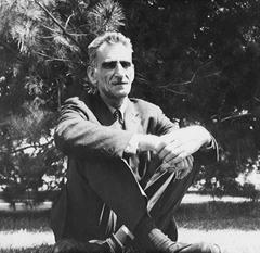 Full length portrait of George Oppen sitting on grass, facing forward, Fresno, 1967