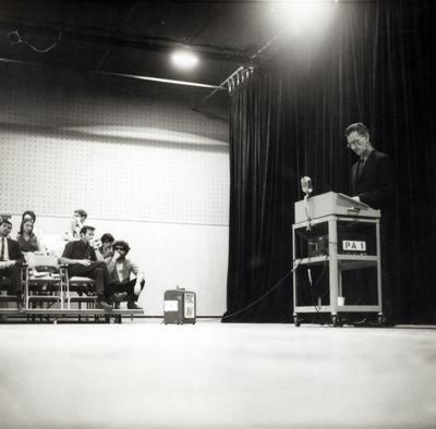 George Oppen, right, standing at a podium during a reading in Fresno, 1967, ver. 3