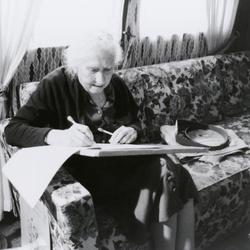 Pauline Ornstein, seated, examining a document, Brownsville TX, 1981