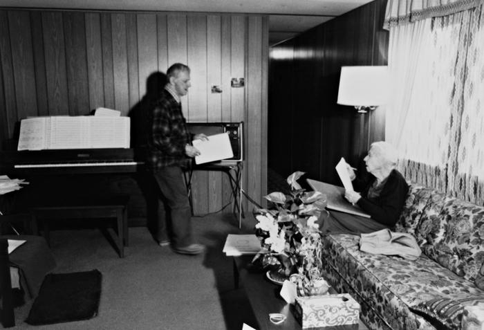 Leo Ornstein, standing next to his piano, facing his seated wife Pauline, Brownsville TX, 1981