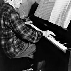 Leo Ornstein playing the piano in his living room, Brownsville TX, 1981