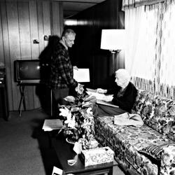 Leo Ornstein standing next to his seated wife Pauline, who is examining a document, Brownsville TX, 1981