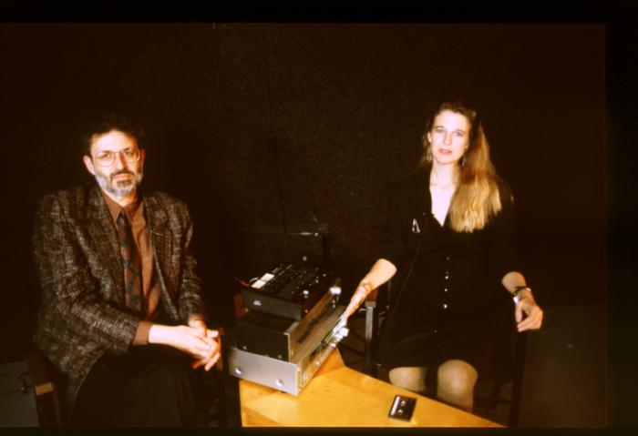 Charles Amirkhanian and Susan Stone, seated onstage with a tape deck during Speaking of Music at the Exploratorium, v.2 (1991)
