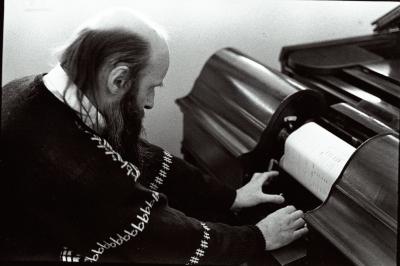 Rex Lawson, head and shoulders portrait, facing down and to the right, adjusting a pianola roll, (1995)