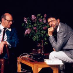 Portrait of Mauricio Kagel and Charles Amirkhanian seated onstage during Speaking of Music at the Exploratorium, San Francisco (1988)